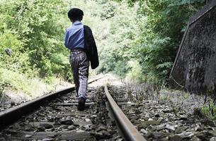 niño caminando en ferrocarril