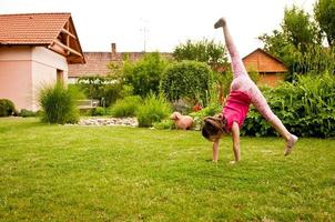 Child doing cartwheel in backyard