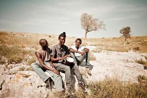 Tres hombres africanos jugando djembe en el prado foto