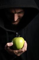monje ofreciendo manzana verde