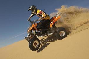 hombre montando en quad en el desierto foto