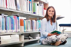 estudiante universitario femenino estudiando en la biblioteca