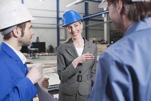 Female architect and foremen in industrial hall photo