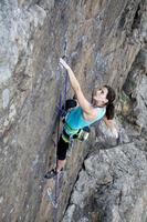Female rock climber hanging over the abyss
