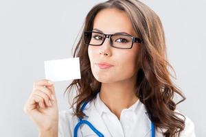 Young female doctor showing blank business card photo