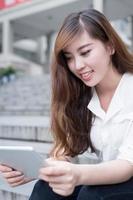 Estudiante asiática con tableta en el campus foto