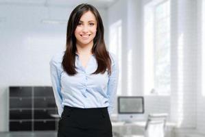 sonriente joven gerente femenina en su oficina
