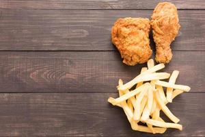 Fried chicken and french fries on a wooden background photo