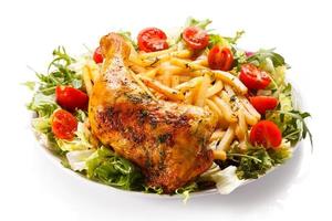 Roasted chicken leg, French fries and vegetables
