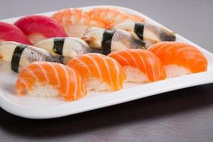 Japanese cuisine. Set of sushi nigiri on white plate. photo