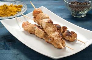 Indonesian chicken satay skewers with curry photo
