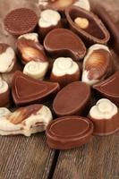 Different kinds of chocolates on wooden table close-up photo