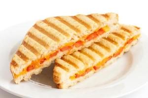clásico sándwich de tomate y queso tostado en plato blanco. foto