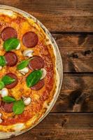 Rustic pizza with salami, mozzarella and spinach