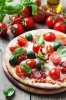 pizza italiana caliente con salami, aceituna y tomate