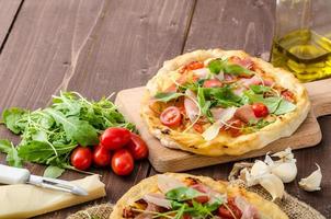 pizza italiana con queso parmesano, prosciutto y rúcula