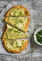 pizza with zucchini, onion and cheese on a wooden background photo