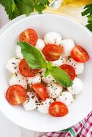 salad with mozzarella, basil and cherry tomatoes, vertical photo