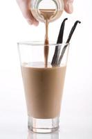 verter leche con chocolate en un vaso foto