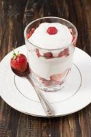 Strawberries with whipped cream in a glass. photo