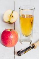 Apple juice freshly squeezed in glass on wood photo