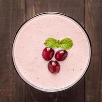 Cranberry fruit smoothie on wooden background, healthy eating.