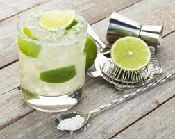 Classic margarita cocktail with salty rim on wooden table photo