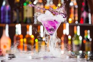 Cocktail with ice vapor on bar desk photo