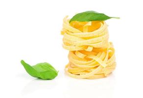 Italian pasta fettuccine nest with basil leaf