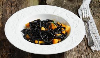 black spaghetti with pumpkin and garlic sauce photo