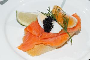 Baguette, smoked salmon, egg, caviar, orange photo