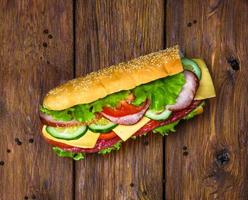 sandwich con carne y verduras en madera