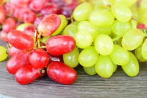 green and red natural grapes on a wooden plate photo