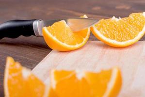 rodajas de naranja deliciosa apetitosa madura en tabla de cortar junto a