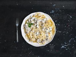 Pasta spaghetti with creamy mushroom sauce and basil in white photo