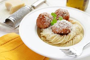 Pasta with Meatballs in tomato sauce, watercress and parmesan cheese photo