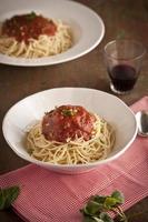 Cena de espagueti con salsa de tomate y albahaca de cerca