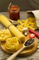 Ingredients for cooking pasta on wooden background.