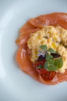 salmón ahumado, huevos revueltos y guarnición de tomate cherry.
