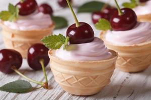mini tartlets with pink cream and cherries. closeup horizontal