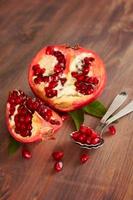Fresh ripe pomegranate with leaves on a wooden board. Selective