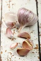 Garlic bulbs and cloves on peeling paint plank table