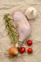 chicken drumstick with tomato, onion, garlic and rosemary photo