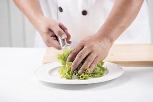 Chef's hands cutting lettuce