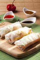Portion of spring rolls on a bamboo board photo