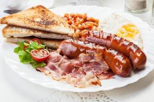 desayuno inglés completo con tocino, salchichas, huevo y frijoles horneados foto