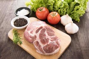 Raw fresh meat and vegetables on wooden background photo