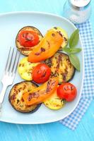 grilled vegetables (zucchini, peppers, tomatoes) on a blue plate