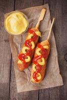 Corn dog with ketchup and mustard photo