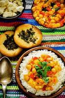 arroz con garbanzos al curry con verduras y pan árabe plano con hierbas